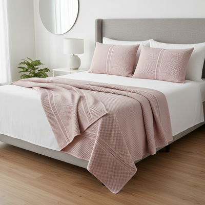 Pink bedsheet and pillows styled on bed in bedroom