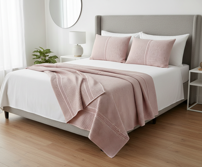 Pink bedsheet and pillows styled on bed in bedroom